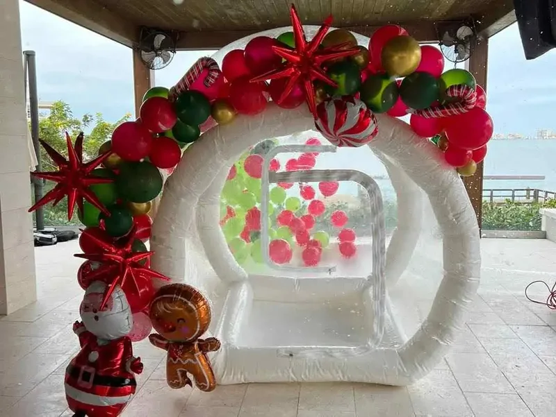 Slumberr bubble house with red and green balloons, Santa and gingerbread decorations.