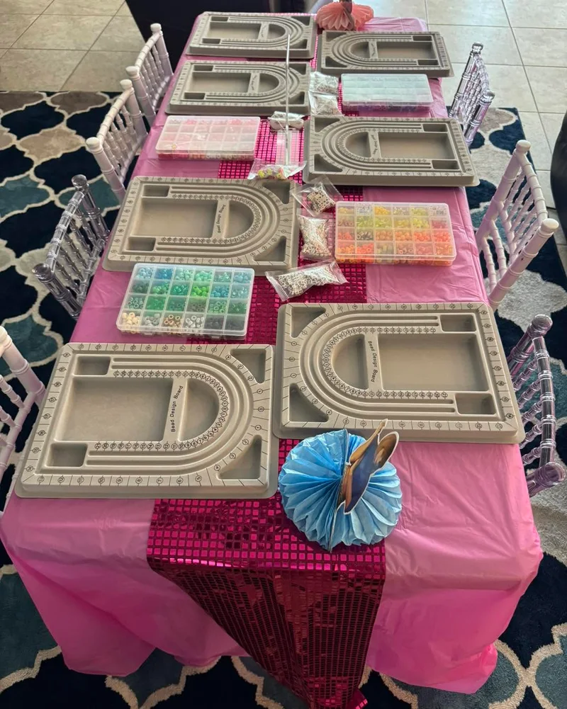 A Slumberr jewelry-making table with bead trays, colorful beads and jewelry tools.