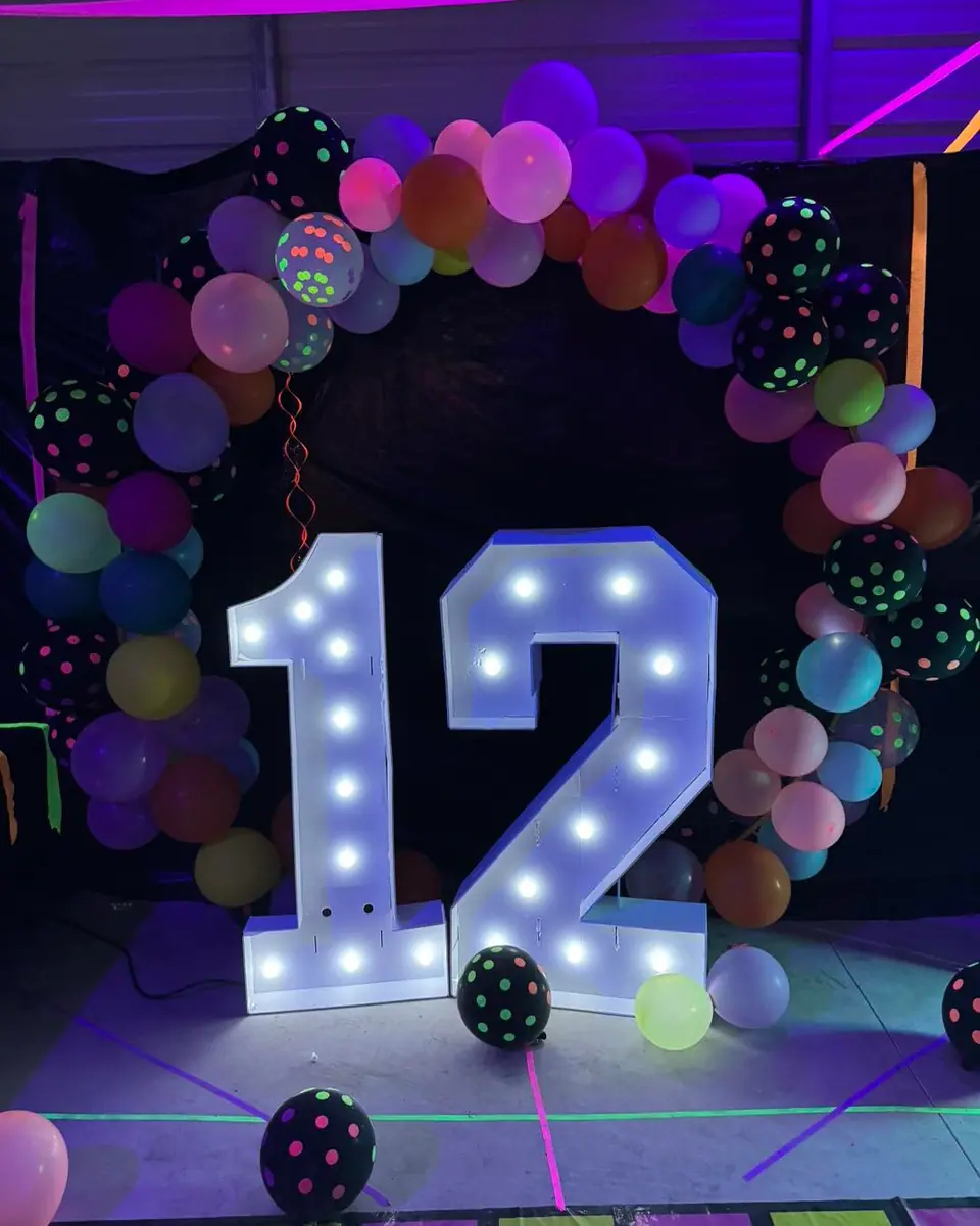 Light-up number 12 and neon balloons at a Slumberr glow party