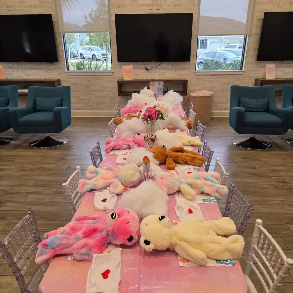 Long table of plush bears and flowers ready for a build-a-bear party