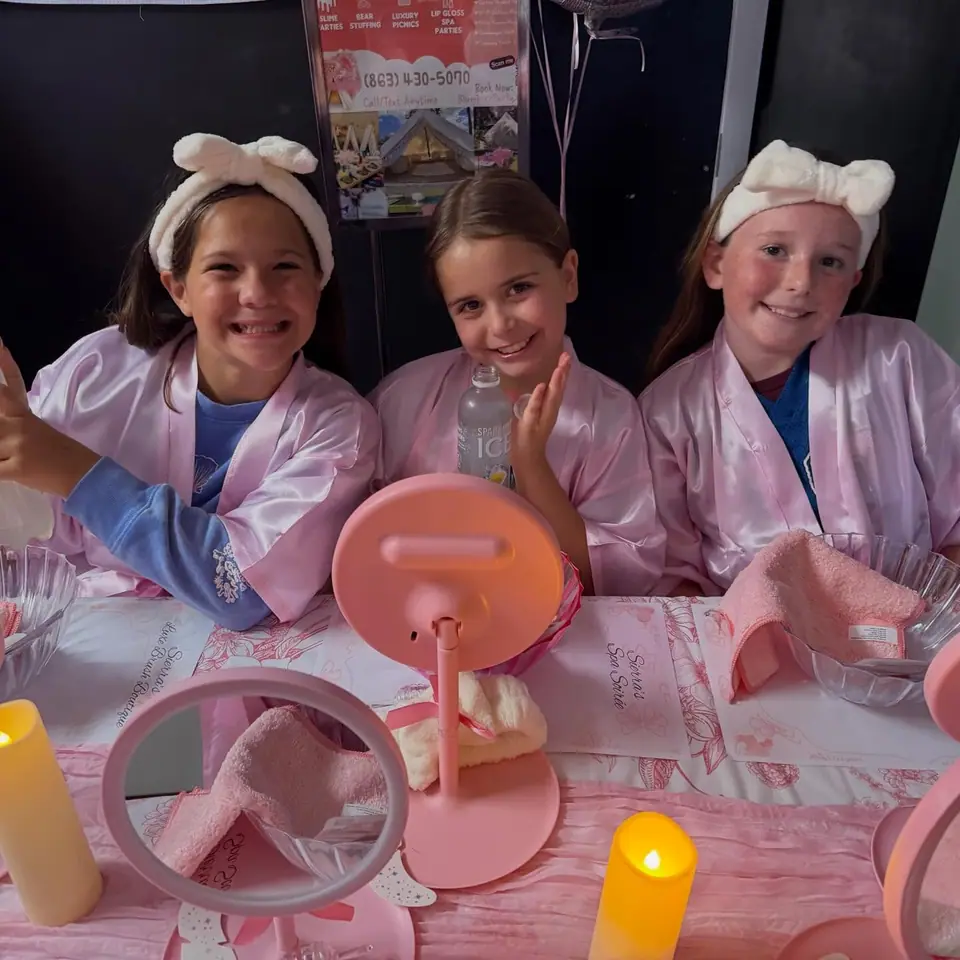 Three girls in pink spa robes and headbands at a Slumberr spa party