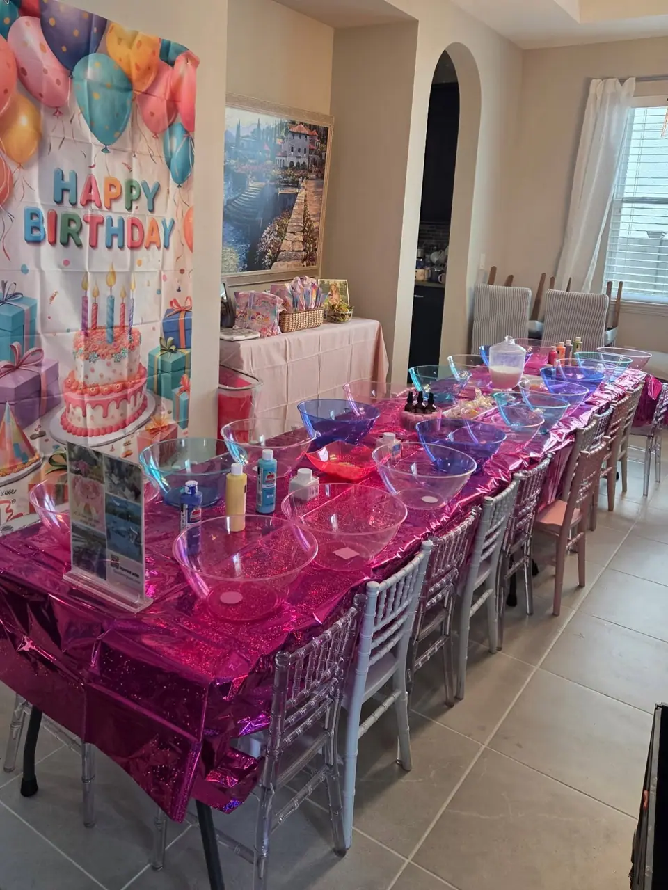 Slime party table with bowls, mix-ins and a birthday backdrop