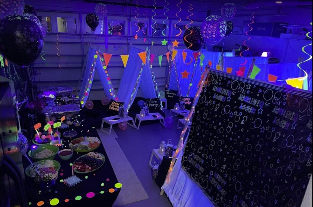 Indoor party venue decorated with a space theme, featuring a tent, balloons, a blackboard with chalk drawings, and a table with snacks for a Winter Haven FL party.